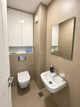 Moderno opremljeno kupatilo sa lavaboom, ogledalom i toaletom u bež tonovima. - image 8
