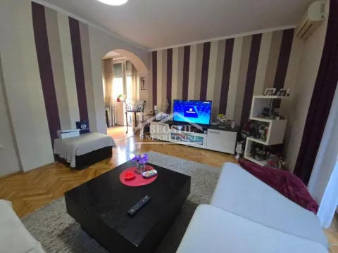 Dnevna soba sa garniturom, televizorom i trpezujućim prolazom ka terasi. - image 3