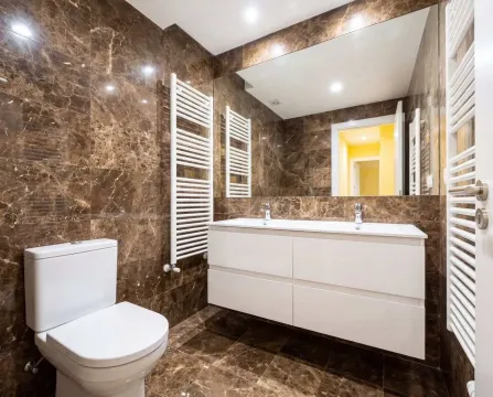 Modern bathroom with white sanitary ware and brown marble tiles. - image 16