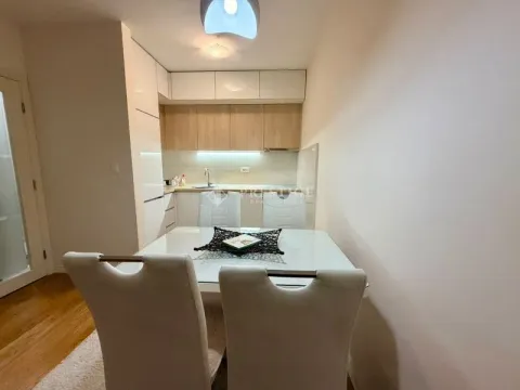 Modern kitchen with dining area and white cabinetry. - image 5