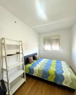 Namještena spavaća soba sa bračnim krevetom i bijelom policom. - image 11