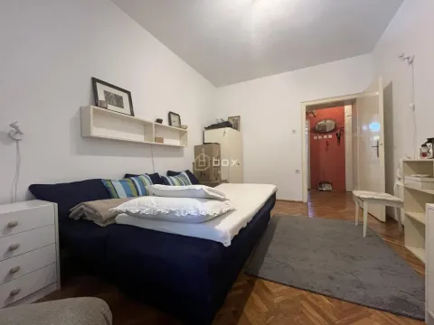 Manja spavaća soba sa krevetom i policom na zidu. - image 5