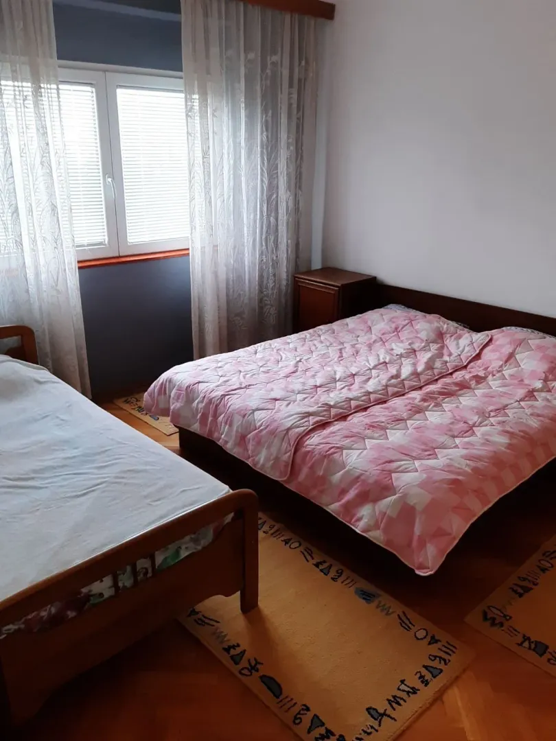 Bedroom with two beds and a window.