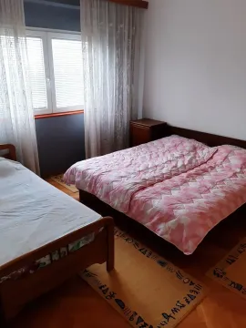 Bedroom with two beds and a window. - image 8