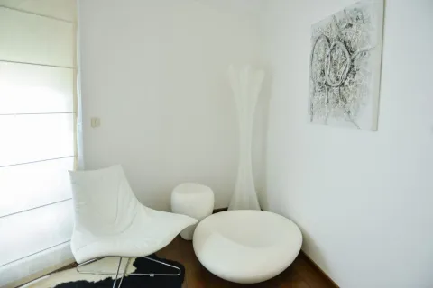 Ugao dnevne sobe sa bijelom foteljom, stočićem i modernom lampom. - image 10
