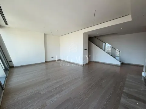 Prazna prostorija sa drvenim podom i stepeništem u uglu. - image 2