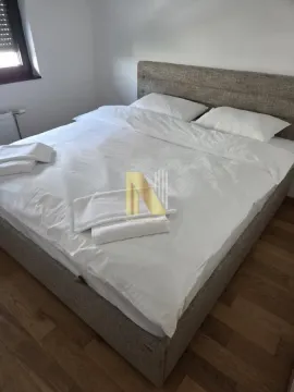 Spavaća soba sa velikim bračnim krevetom namestenem belom posteljinom. - image 9