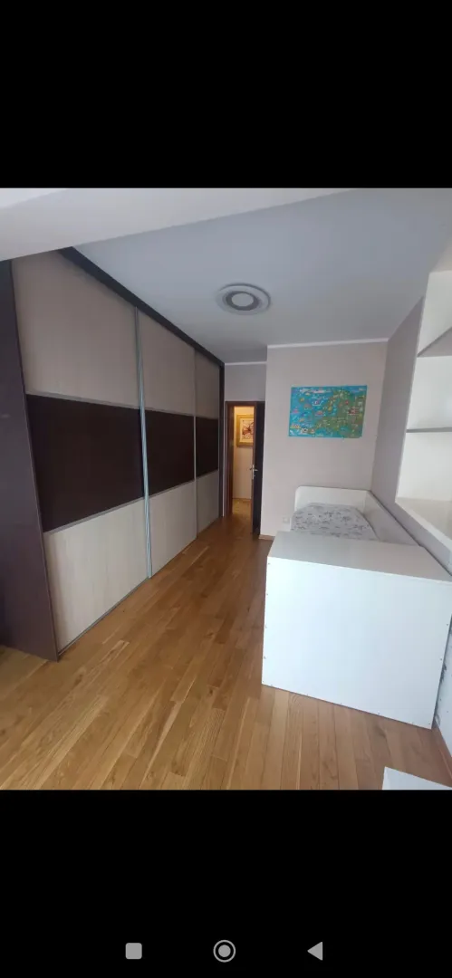 Children's bedroom with a large built-in wardrobe and a bed.