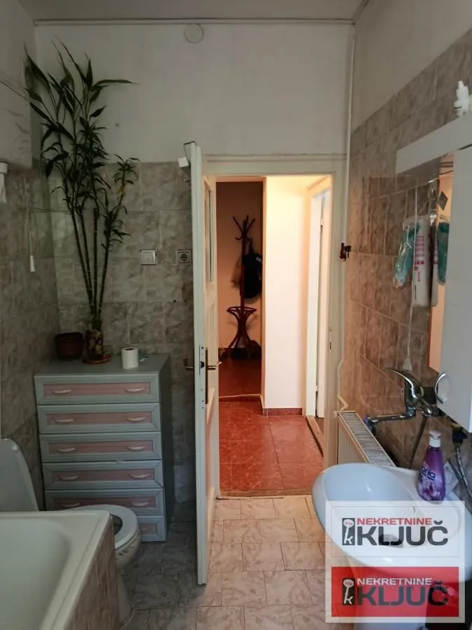 Manje kupatilo sa lavaboom, wc šoljom i pločicama na zidovima.