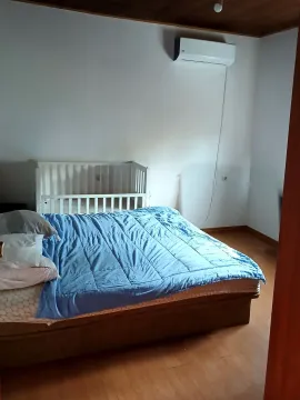 Bedroom with a double bed, baby crib, and air conditioning unit. - image 6