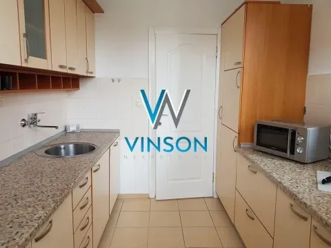 Kuhinja sa drvenim elementima, sudoperom i radnom površinom. - image 10