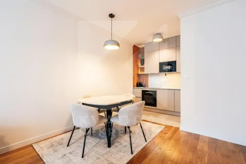 Dining area with a table and chairs overlooking the kitchen in the background. - image 3