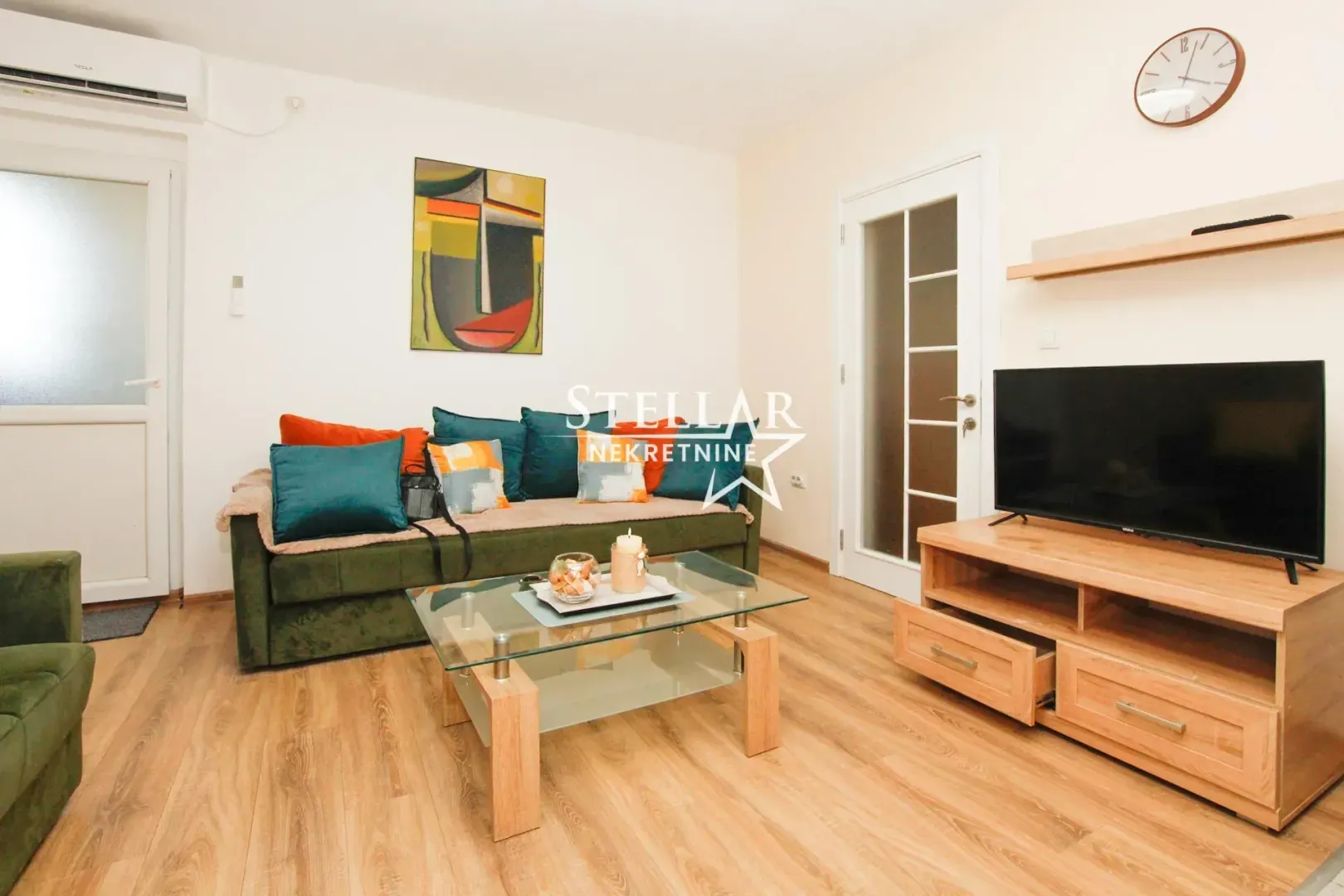 Living room with a sofa, TV, and wooden coffee table.