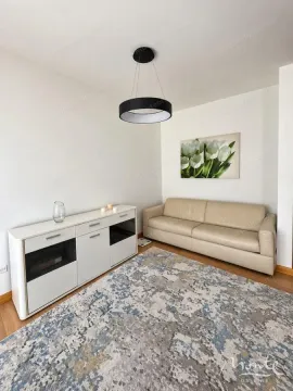 Dnevna soba sa bež kaučem, bijelom komodom i modernim lusterom. - image 7