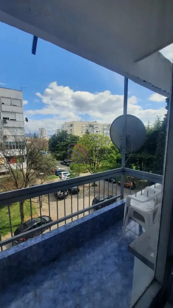 View from the balcony towards surrounding buildings and green areas.