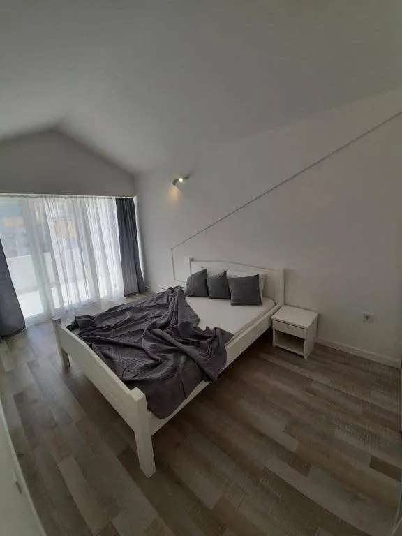 Svijetla spavaća soba sa bračnim krevetom i izlazom na terasu.