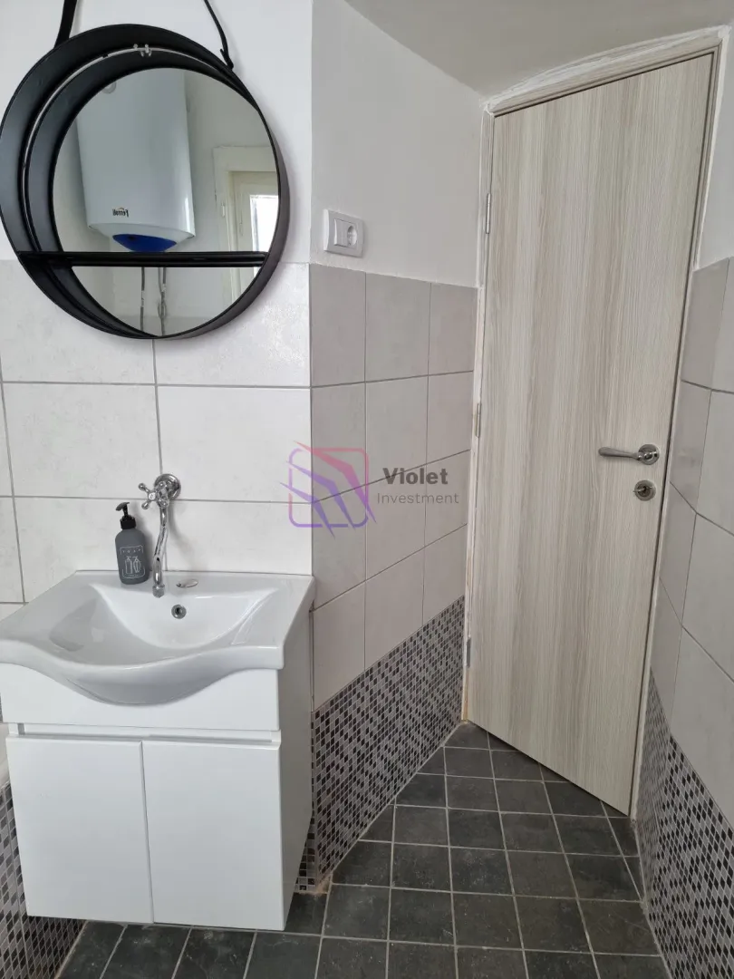 Bathroom with a sink, mirror, and door.