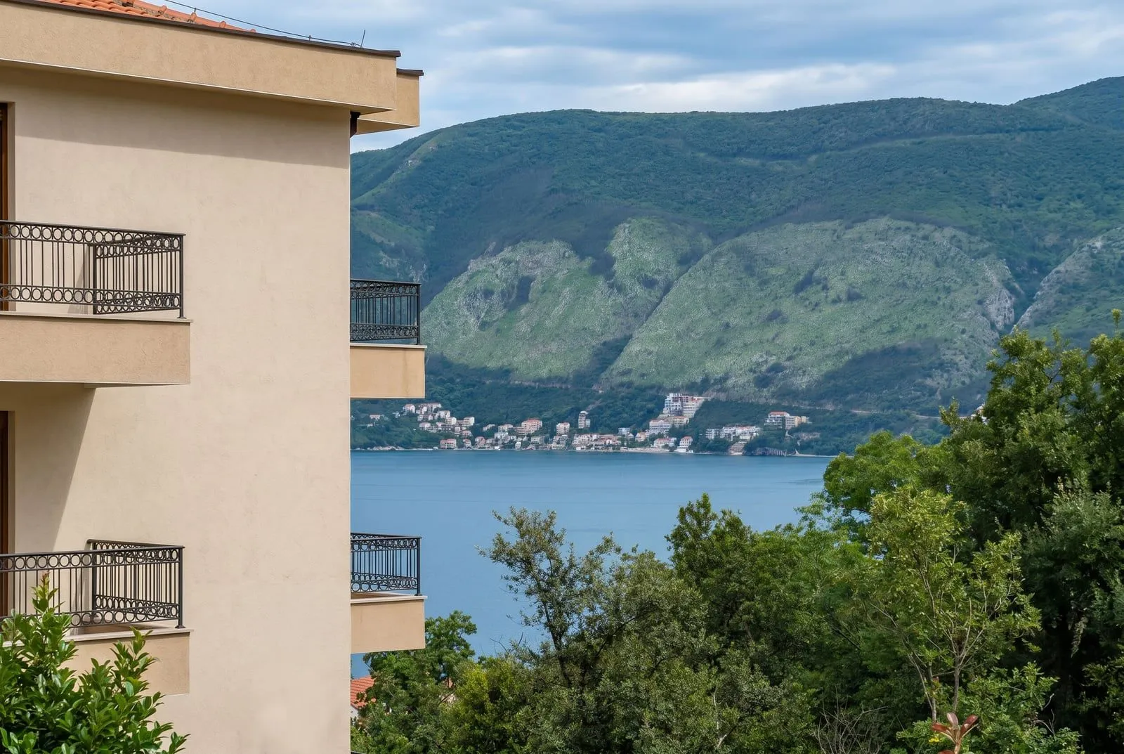 Pogled na more i planine sa balkona stambene zgrade.