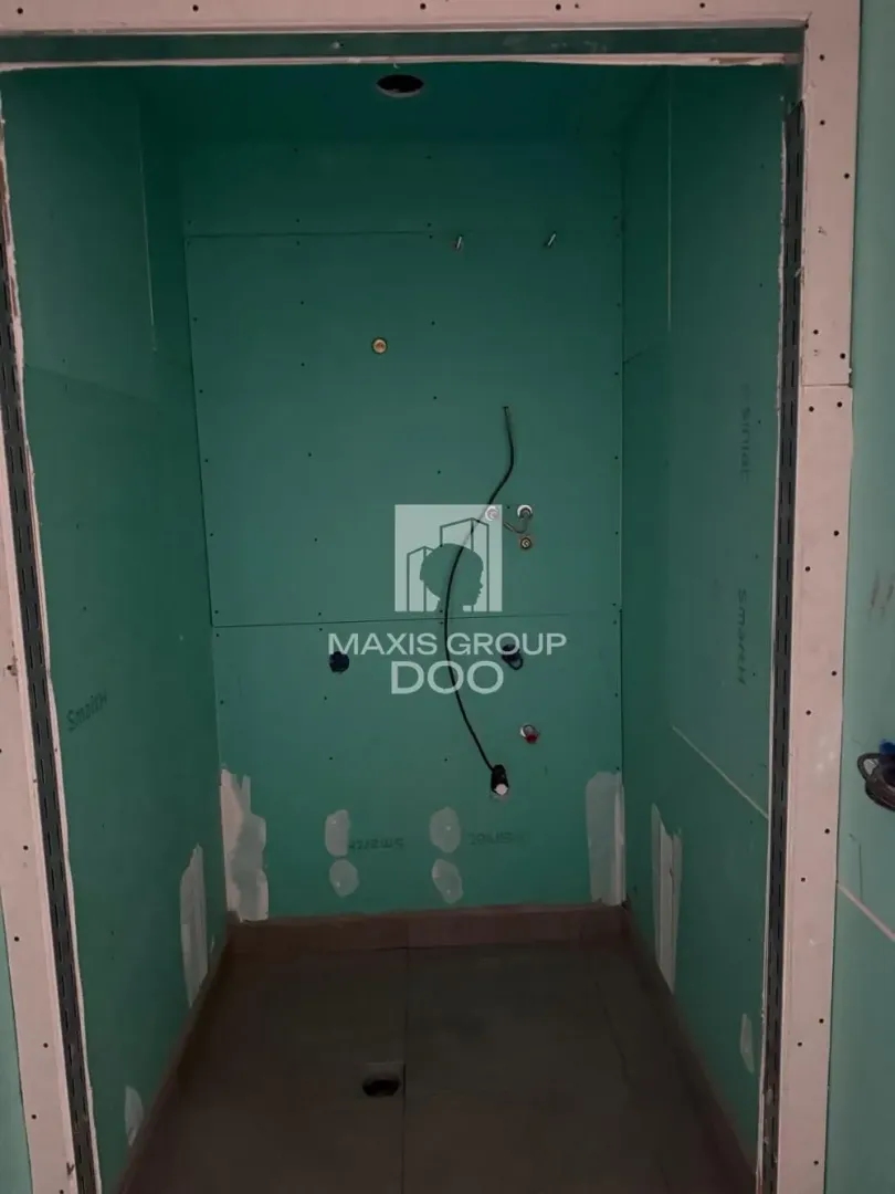 A view of a room under construction lined with green plasterboard.