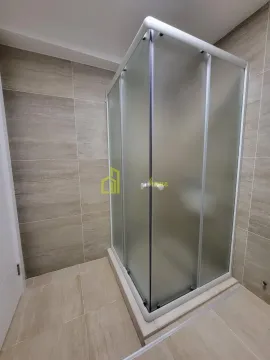 Bathroom with a shower cabin tiled in neutral tones. - image 9