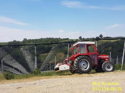 Crveni traktor parkiran u voćnjaku sa zaštitnom mrežom. - image 7