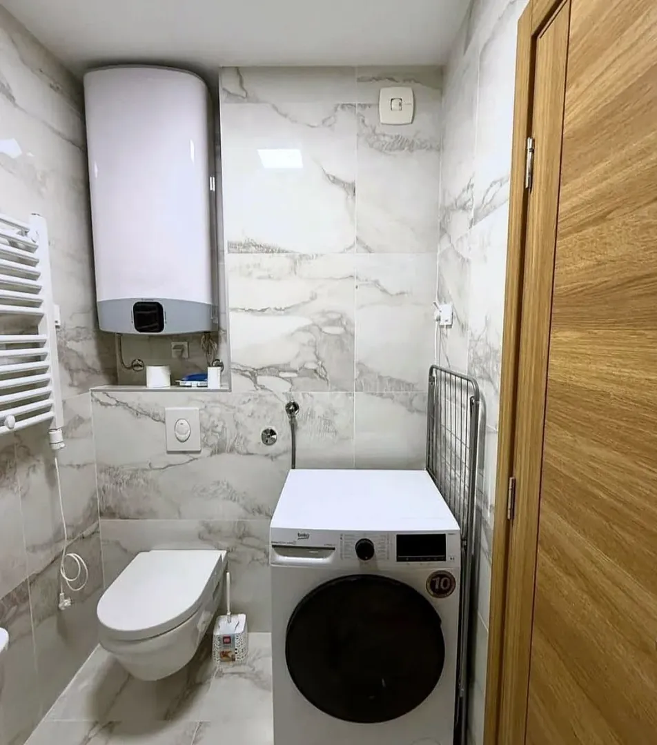 Bathroom equipped with sanitary ware, water heater and washing machine.