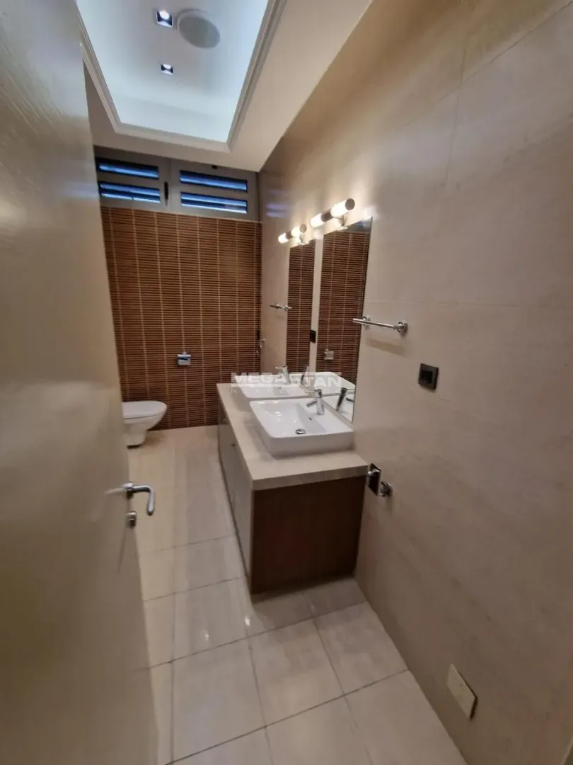 Moderno kupatilo sa umivaonikom, ogledalom i wc šoljom.