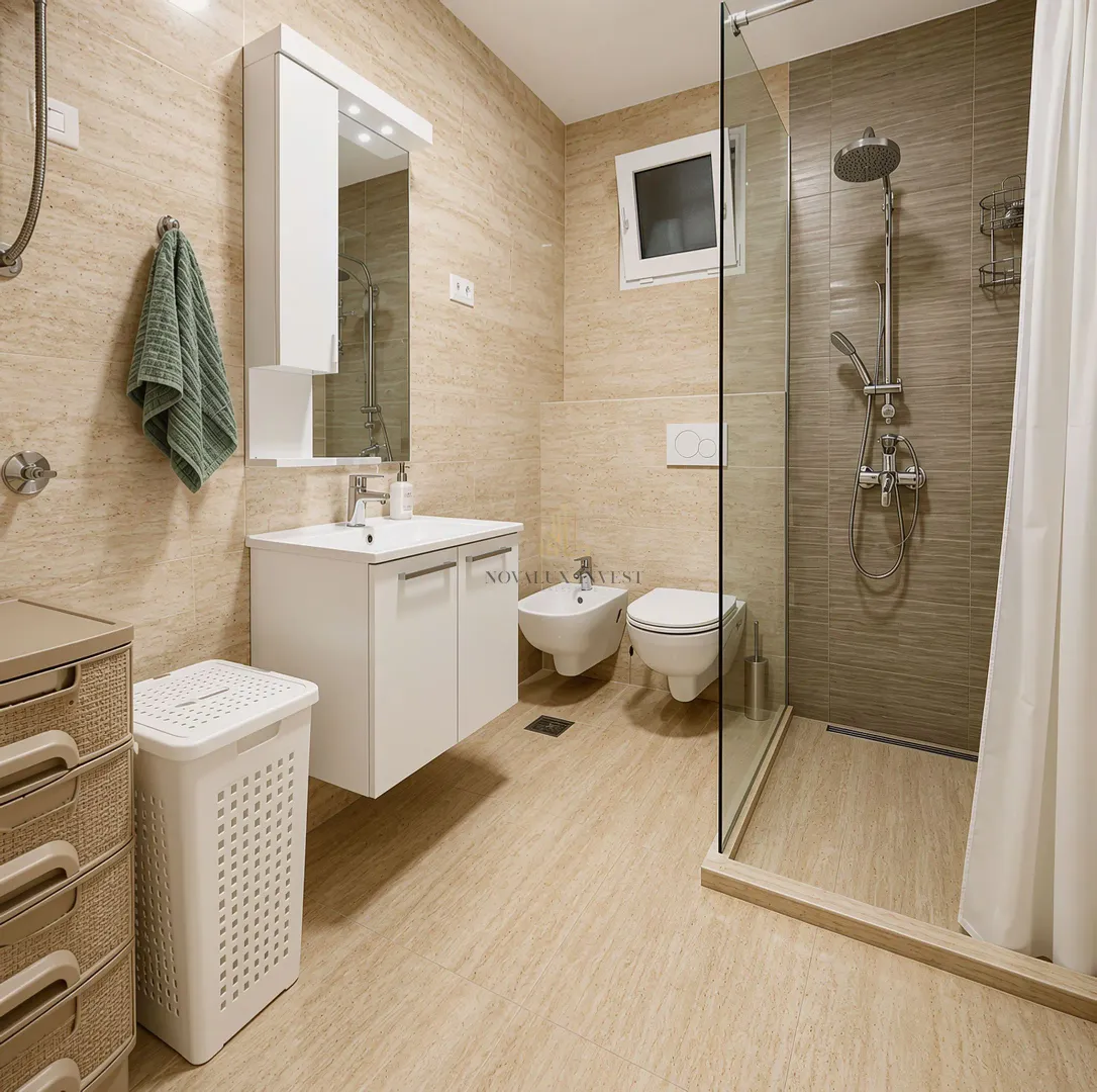 Moderne kupatilo sa tuš kabinom, umivaonikom i ugradnom sanitarijom.