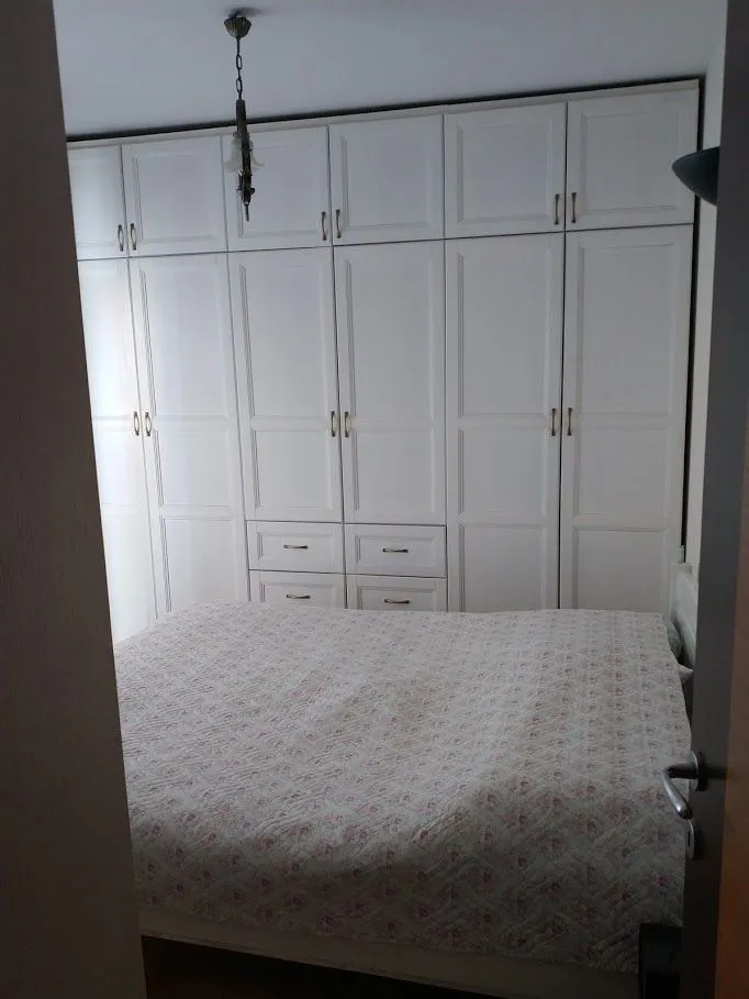 Svijetla spavaća soba sa ugradnim plakarom.