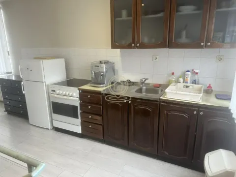 Kitchen with dark wooden cabinets, white appliances, and a sink. - image 6
