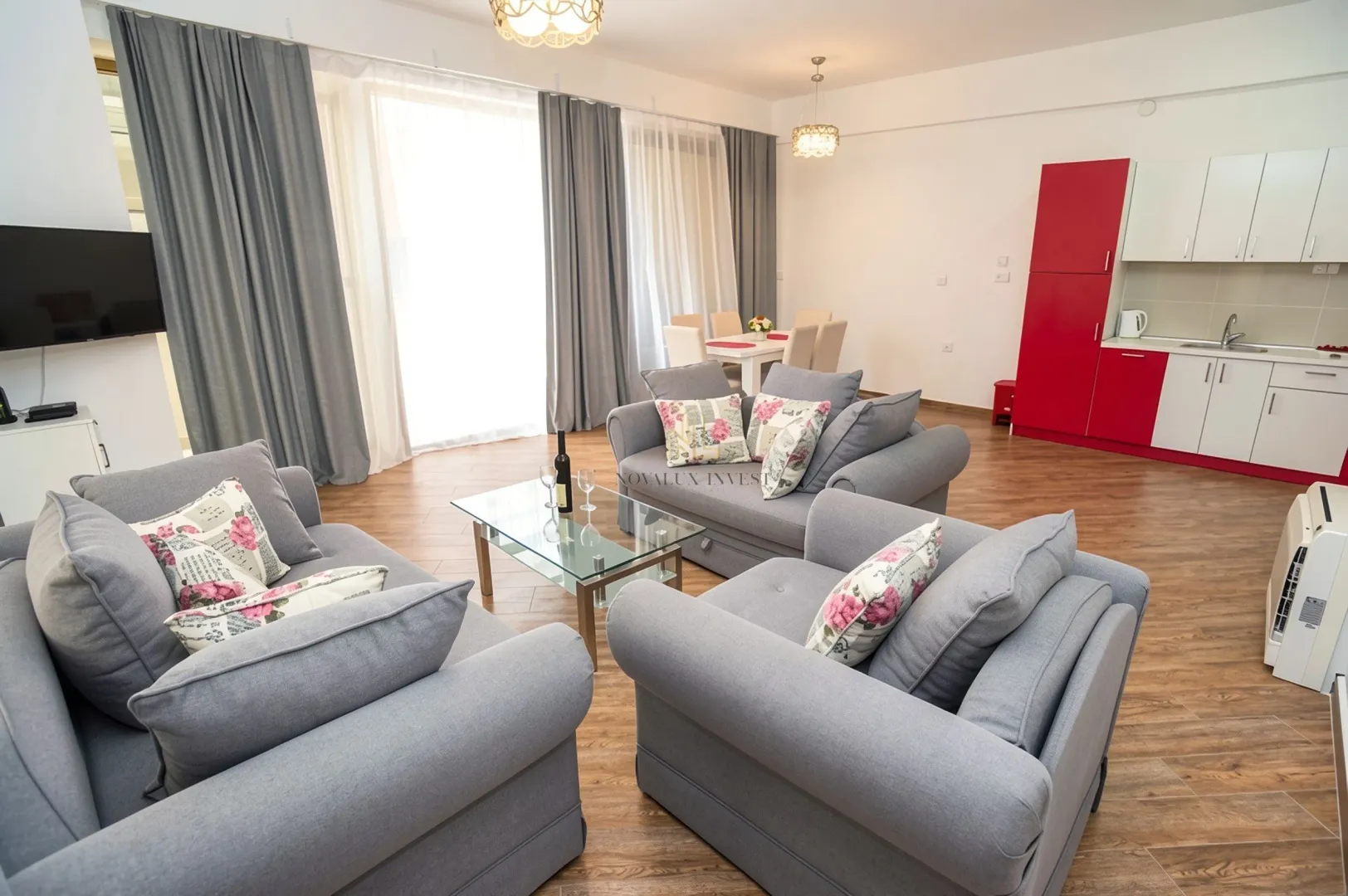 Spacious living room with a seating set and a built-in kitchen in the background.