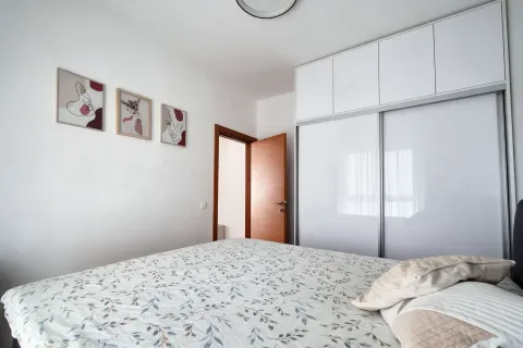 Uređena spavaća soba sa bračnim krevetom, velikim garderoberom i slikama na zidu. - image 13