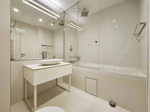 Modernly equipped bathroom with a bathtub and a sink. - image 9