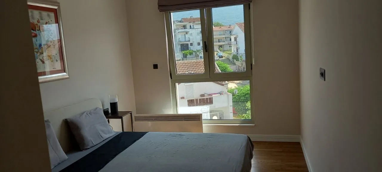 Bedroom with a double bed and a window with a view of the neighborhood.