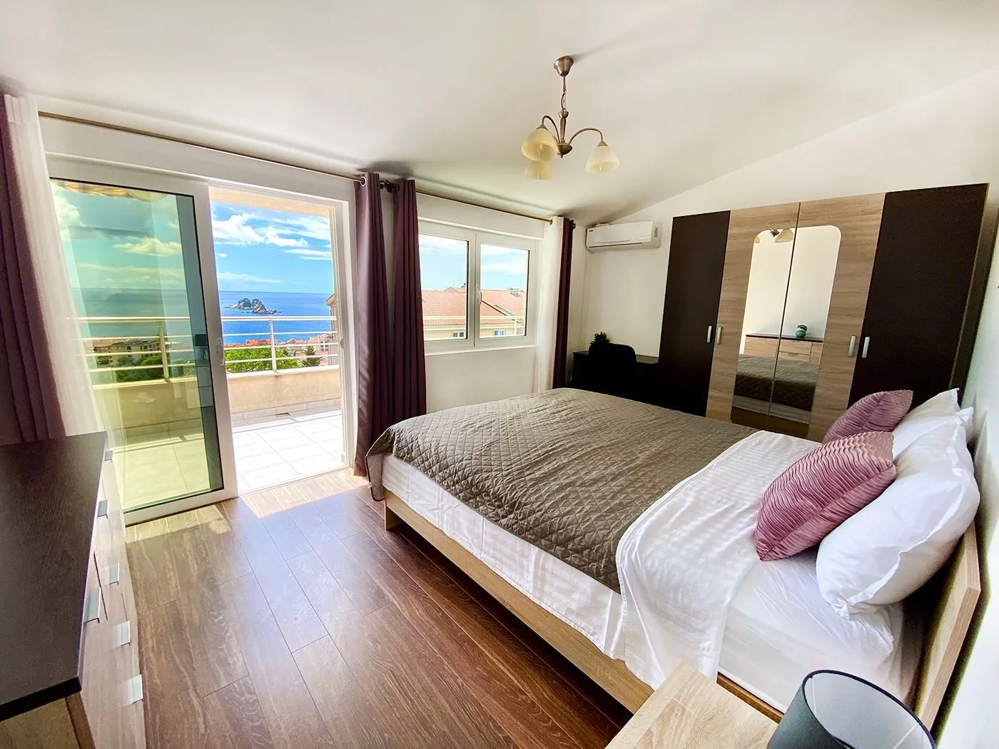 Furnished bedroom with a double bed and access to a terrace with a sea view.