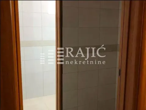 View of a tiled bathroom through an open door. - image 17
