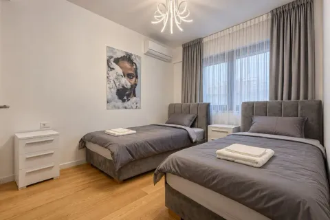 Modern bedroom with two single beds, parquet flooring, and a large window. - image 9