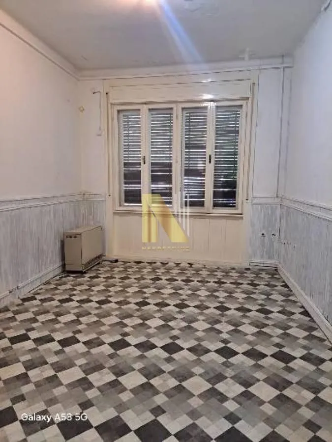 Empty room with a window and tiled floor.