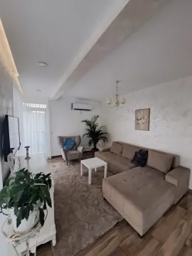 Dnevna soba opremljena ugaonom garniturom, foteljom, stočićem i TV komodom. - image 22