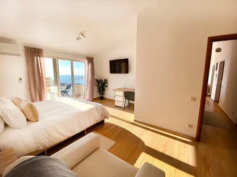 Bright bedroom with a double bed, desk, and access to a terrace with a sea view. - image 3
