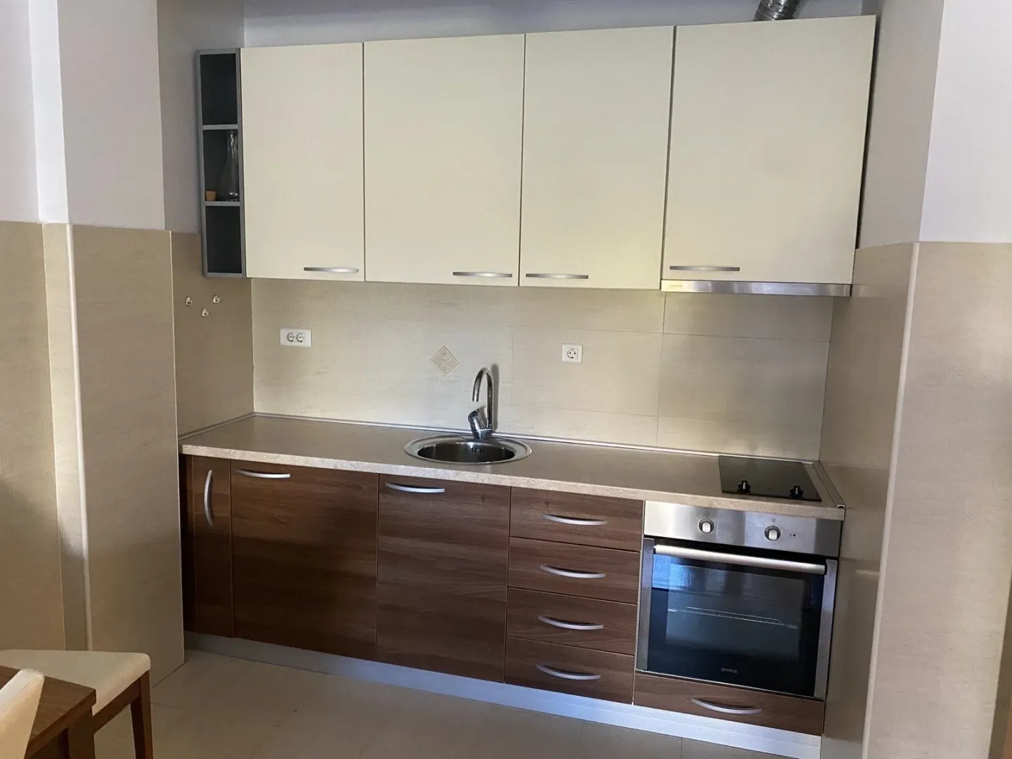 Simple kitchen with built-in appliances and a sink.