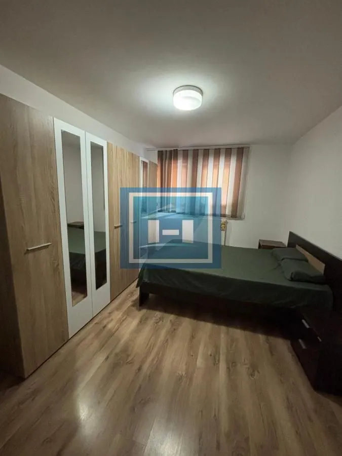 Spavaća soba sa bračnim krevetom i velikim ormanom.