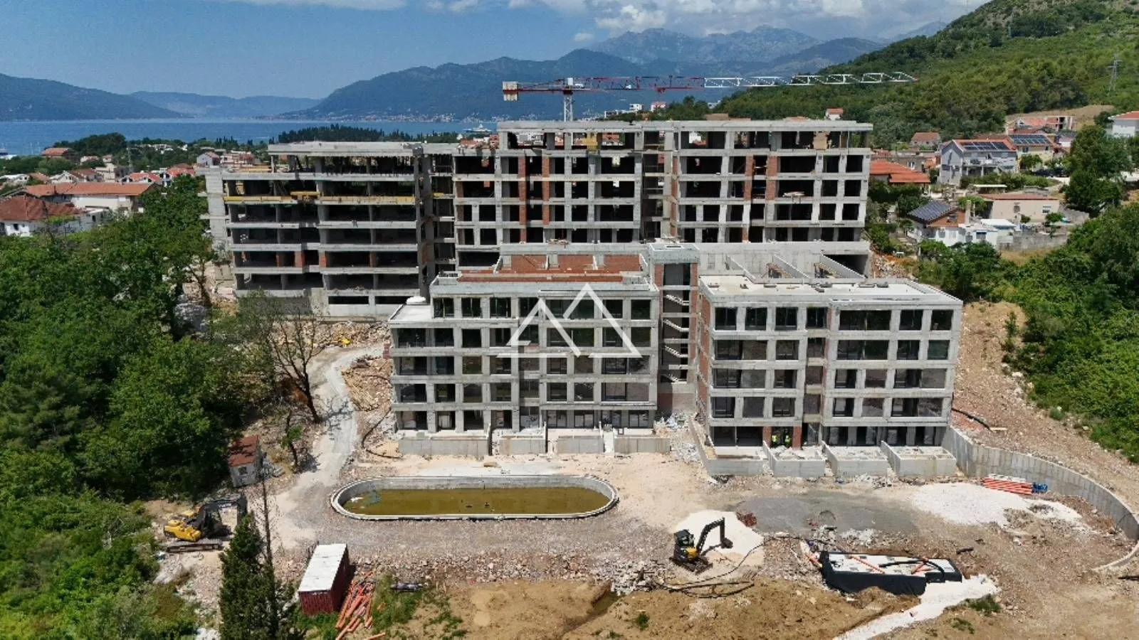 Pogled iz vazduha na stambeni kompleks u izgradnji sa bazenom.