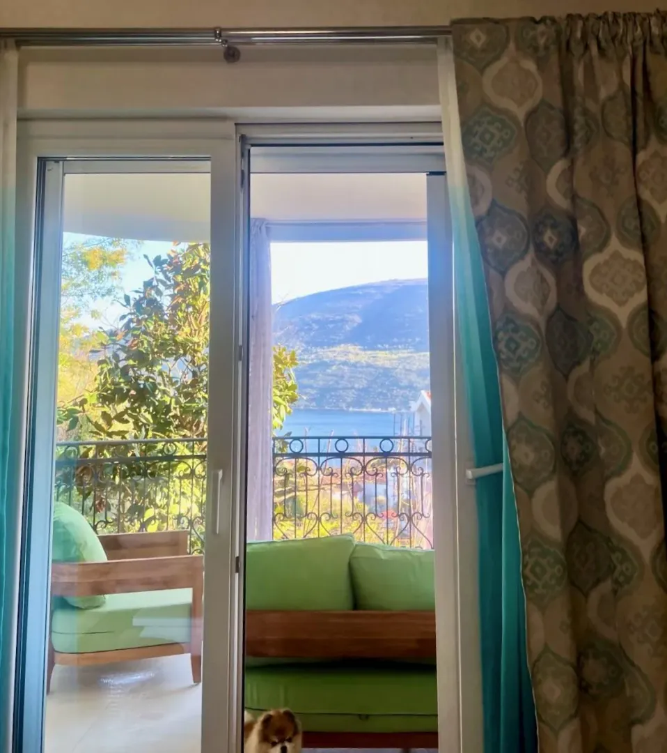 Pogled na more i planine kroz balkonska vrata namještenog stana.