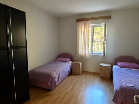 Bedroom with two single beds, a wardrobe, and a window. - image 5