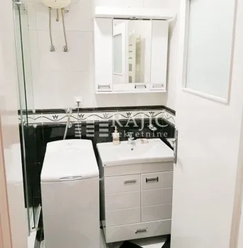 Small bathroom with a sink, mirror, washing machine, and shower cabin. - image 9
