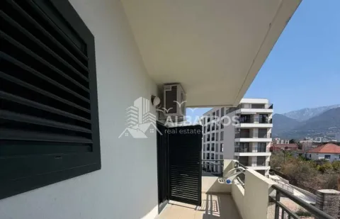 Natkriveni balkonski prostor sa pogledom na okolne zgrade i planine. - image 13