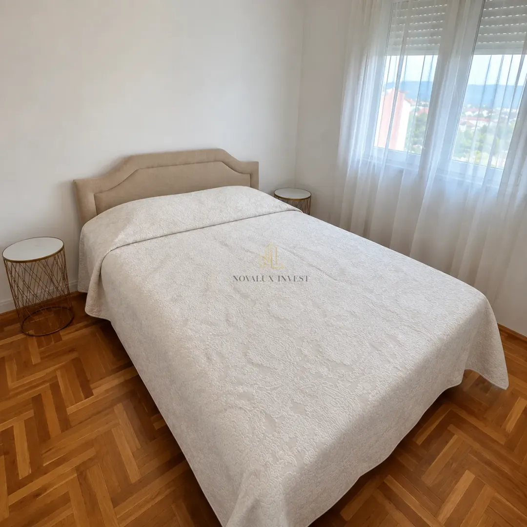 Bedroom with a double bed, nightstands, and parquet flooring.