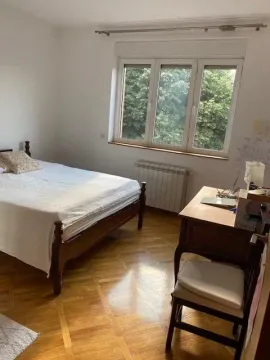 Bedroom with a double bed, wooden parquet flooring, and a desk by the window. - image 9