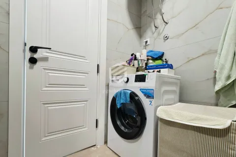 Bathroom with a washing machine and white door. - image 4